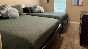 A hotel room with two beds, a dresser, a window with blinds, and two wall-mounted artworks. - Cliff Hanger, River access with dock (Parker)