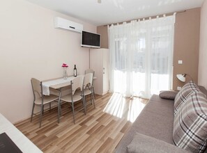 Appartement (One Bedroom Apartment 1) | Woonkamer | Een 32-inch flatscreentelevisie met kabelzenders