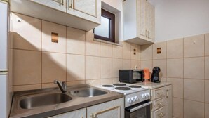 Une cuisine équipée d’un évier, d’une cuisinière, d’un four à micro-ondes et de placards.