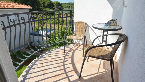 A balcony with a tiled floor, two wicker chairs, a small round table, and a metal railing. - Charming Retreat Near Rovinj With Private Balcony (Rovinj)