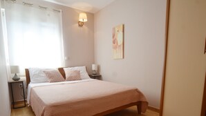 A bedroom with a large bed, bedside lamps, a painting on the wall, and a window with curtains. - Charming Retreat Near Rovinj With Private Balcony (Rovinj)