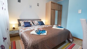 Una camera da letto con un letto, un comodino, un armadio e uno specchio.