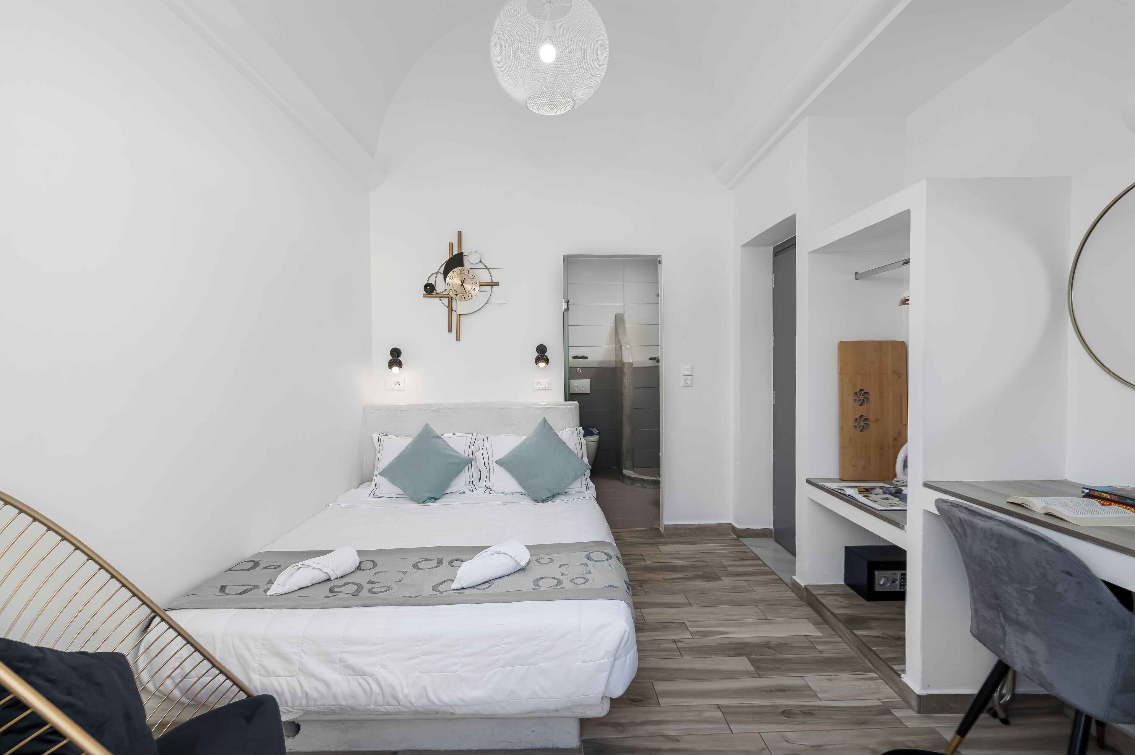A modern hotel room with a neatly made bed, a desk, and a chair.