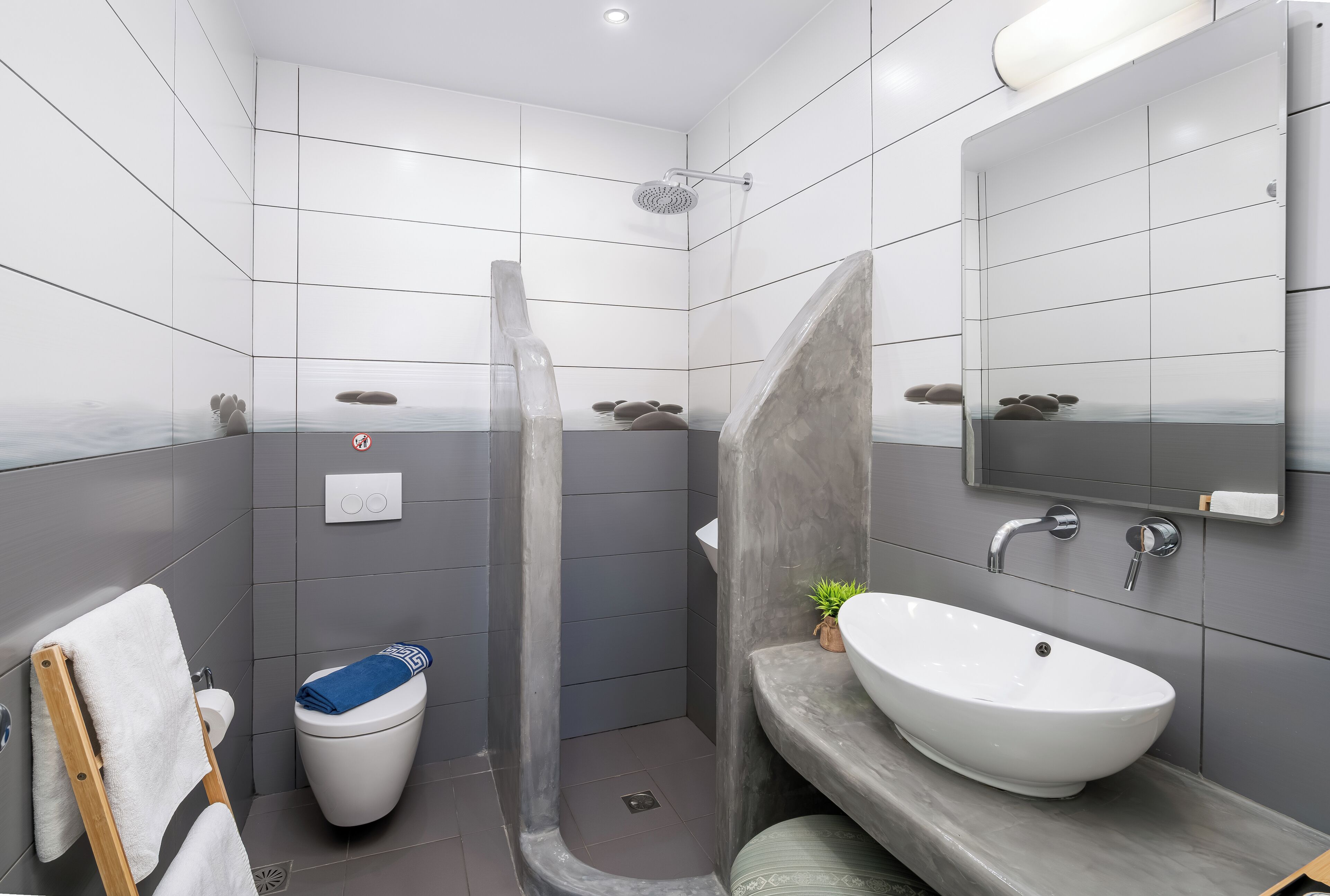 A modern bathroom with a shower, toilet, and sink.