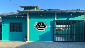 Un edificio residencial con fachada color turquesa, entrada protegida por una reja y un cartel que indica 'Bortolotti Residence'.