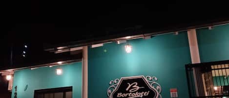 A teal-colored building with a sign reading "Bortolotti Residence" and a black gate.