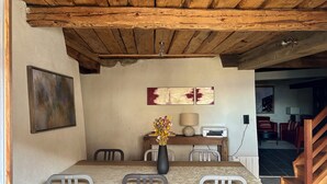 A dining area with a wooden ceiling, a vase with flowers, a painting, and a lamp on a table. - HAUTE-NENDAZ VILLAGE: LARCH 1898 4-STOREY/4-ROOM/6-PERSON CHALET/PARKING. (Nendaz)