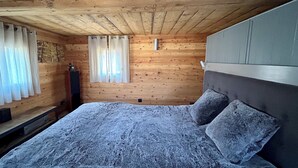 A wooden room with a bed, curtains, and a small table. - HAUTE-NENDAZ VILLAGE: LARCH 1898 4-STOREY/4-ROOM/6-PERSON CHALET/PARKING. (Nendaz)