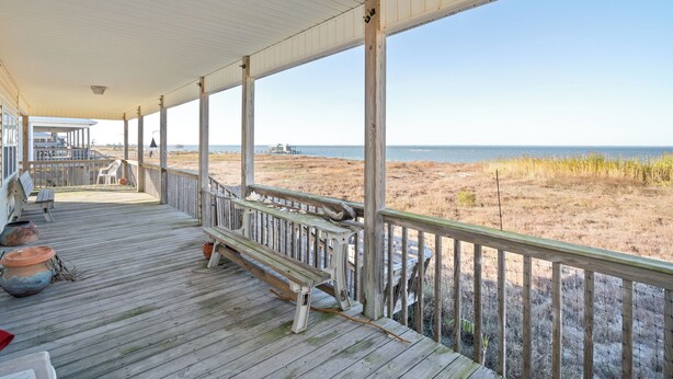 A wooden deck with a railing overlooking a beach. - Sound Front Home with both Gulf & Sound Views! (Dauphin Island)