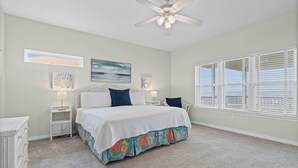 A bedroom with a bed, a ceiling fan, a window with blinds, and wall art. - Sound Front Home with both Gulf & Sound Views! (Dauphin Island)
