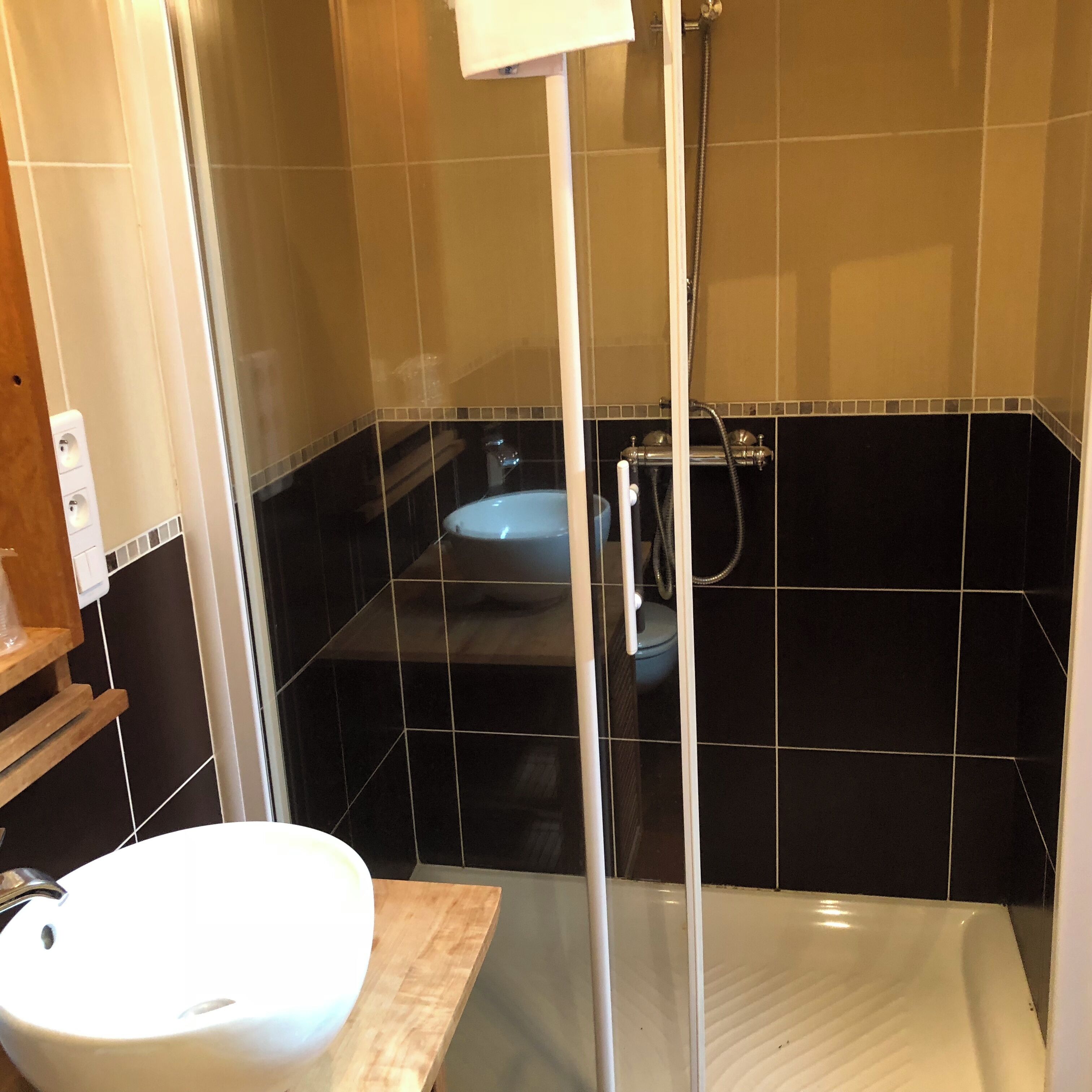Une salle de bain avec un lavabo blanc, un espace douche et des toilettes.