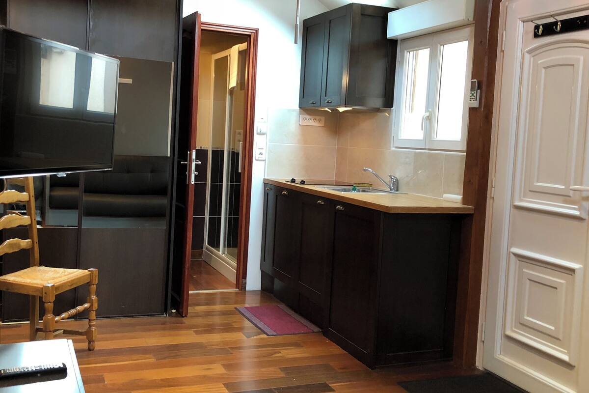 A compact kitchen with dark wooden cabinets, a built-in oven, and a small countertop.