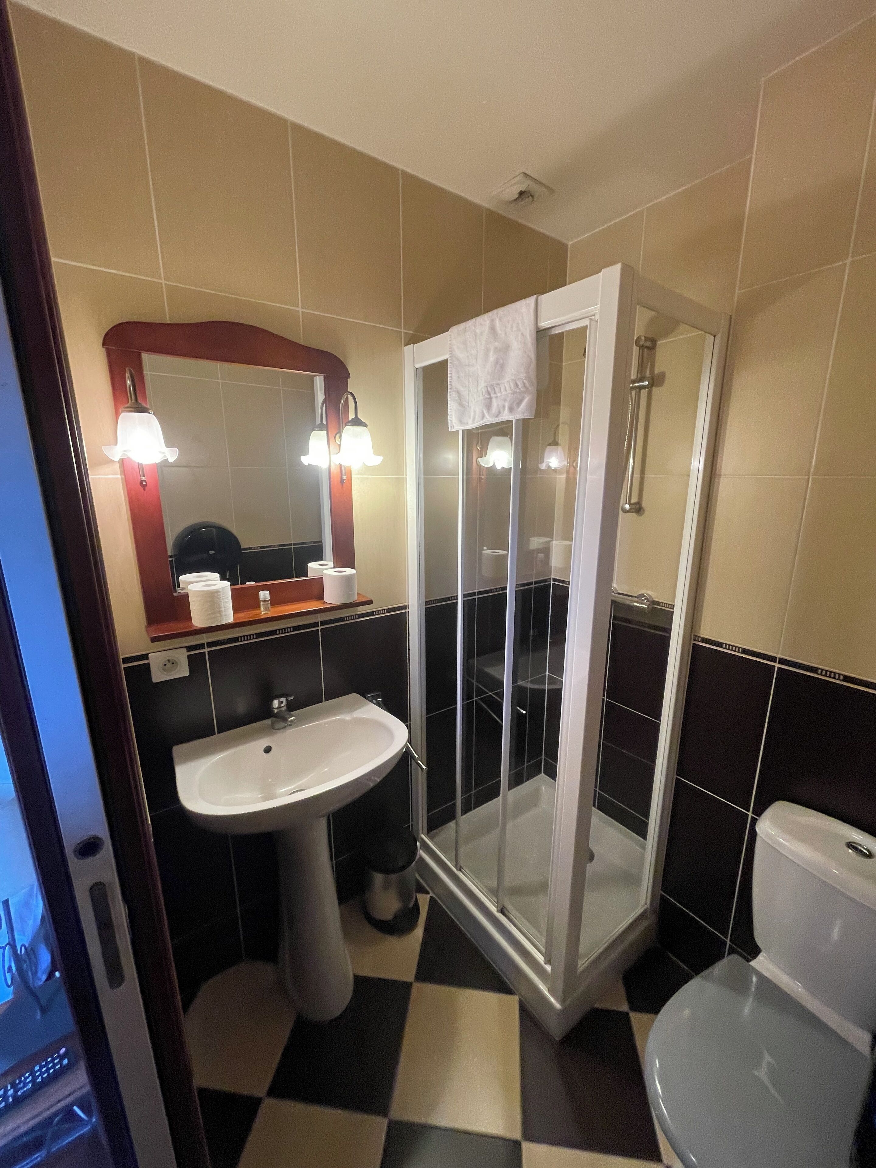 Une salle de bain équipée d’un lavabo, de toilettes et d’une douche à parois de verre.