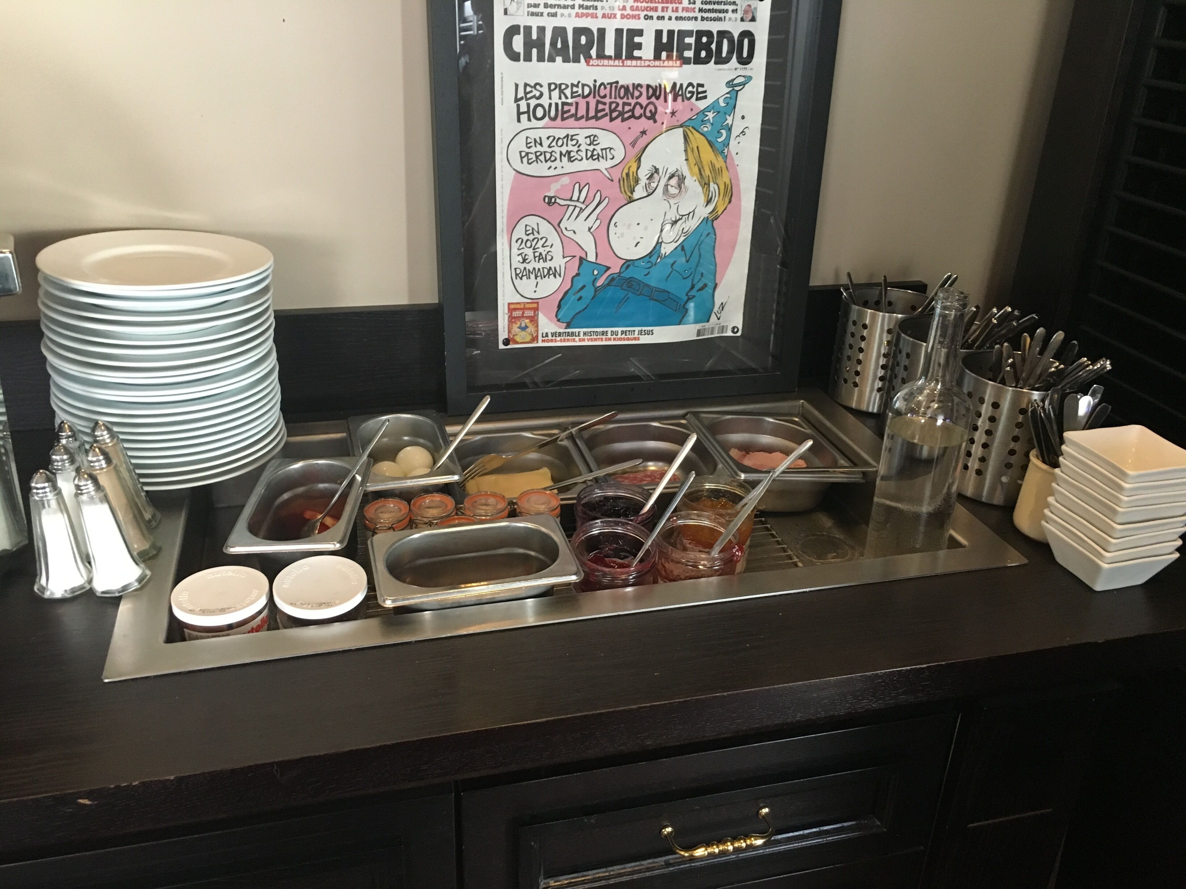 A buffet setup with various food containers and utensils.