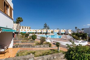 A hotel with a swimming pool, outdoor seating, and a view of other buildings. - RT-Las Brisas (San Bartolomé de Tirajana)