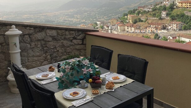 Mesa para dos con vistas a un pueblo en la ladera.
