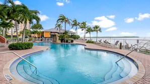 A swimming pool with a 3 FT 3 IN depth marker, surrounded by palm trees and a view of the water. - Lovers Key Resort 308 (Fort Myers Beach)