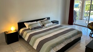 A bedroom with a bed, nightstands, a lamp, and a view of a balcony. - Swiss 53-lake Denise (Clermont)