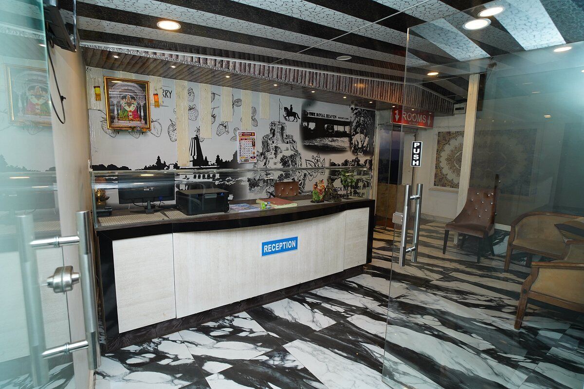 A reception area with a marble floor, a reception desk labeled "RECEPTION," and a wall decorated with various black and white images and a framed picture.
