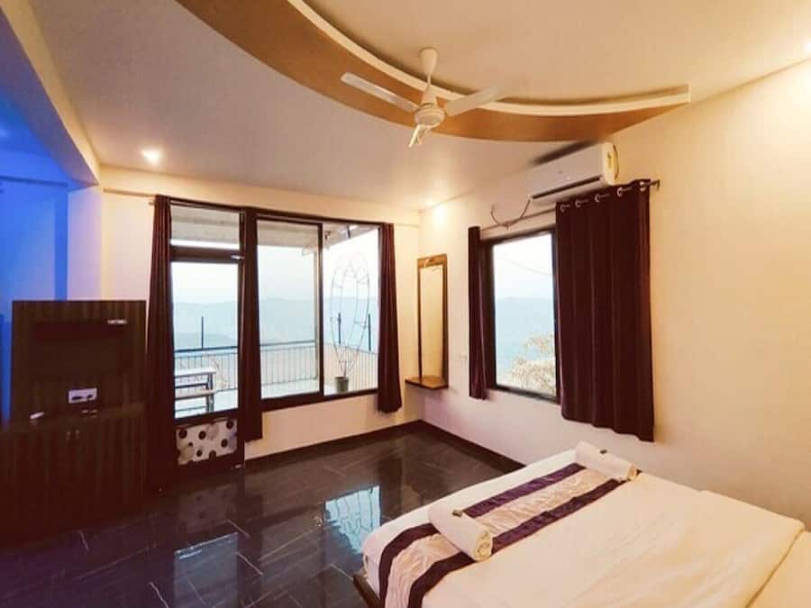 Habitación de hotel con cama, televisor, ventilador de techo y una ventana grande con vistas.