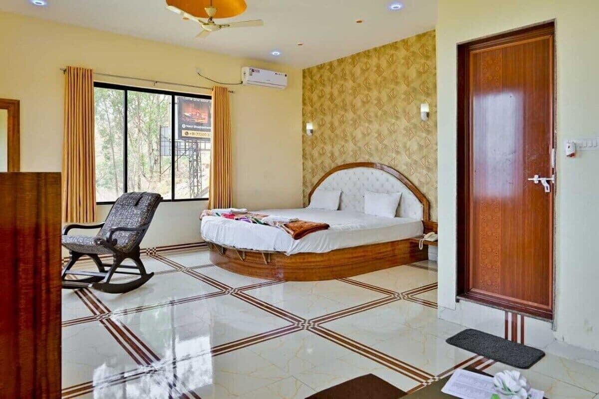Quarto com cama, cadeira de balanço, janela e porta.