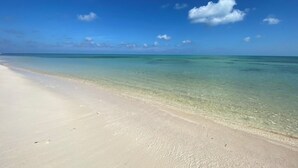 A beach with clear turquoise water and a sandy shore.