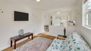 Relax in this cozy living space with a flat-screen TV, plush sofa, and comfortable bench.
