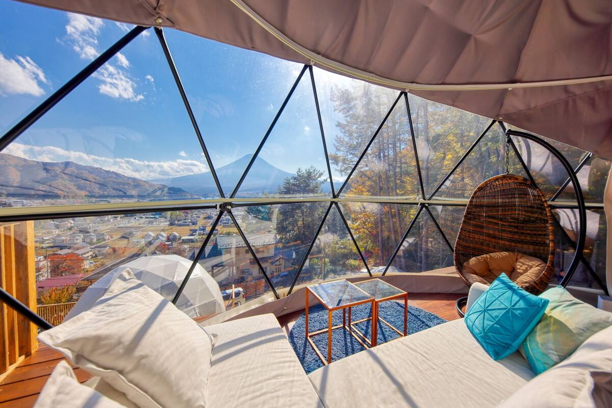 Ein gemütliches Interieur mit einem großen Fenster, das einen malerischen Blick auf eine Stadt und Berge bietet.