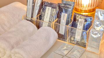 A display of toiletries including facial lotion, razor, and other personal care items, alongside neatly folded towels.