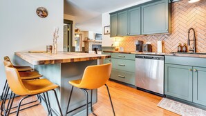 A modern kitchen with a wooden island, bar stools, and green cabinets. - Forested Retreat w/ Sauna: 5 Mi to Schroon Lake (Schroon Lake)