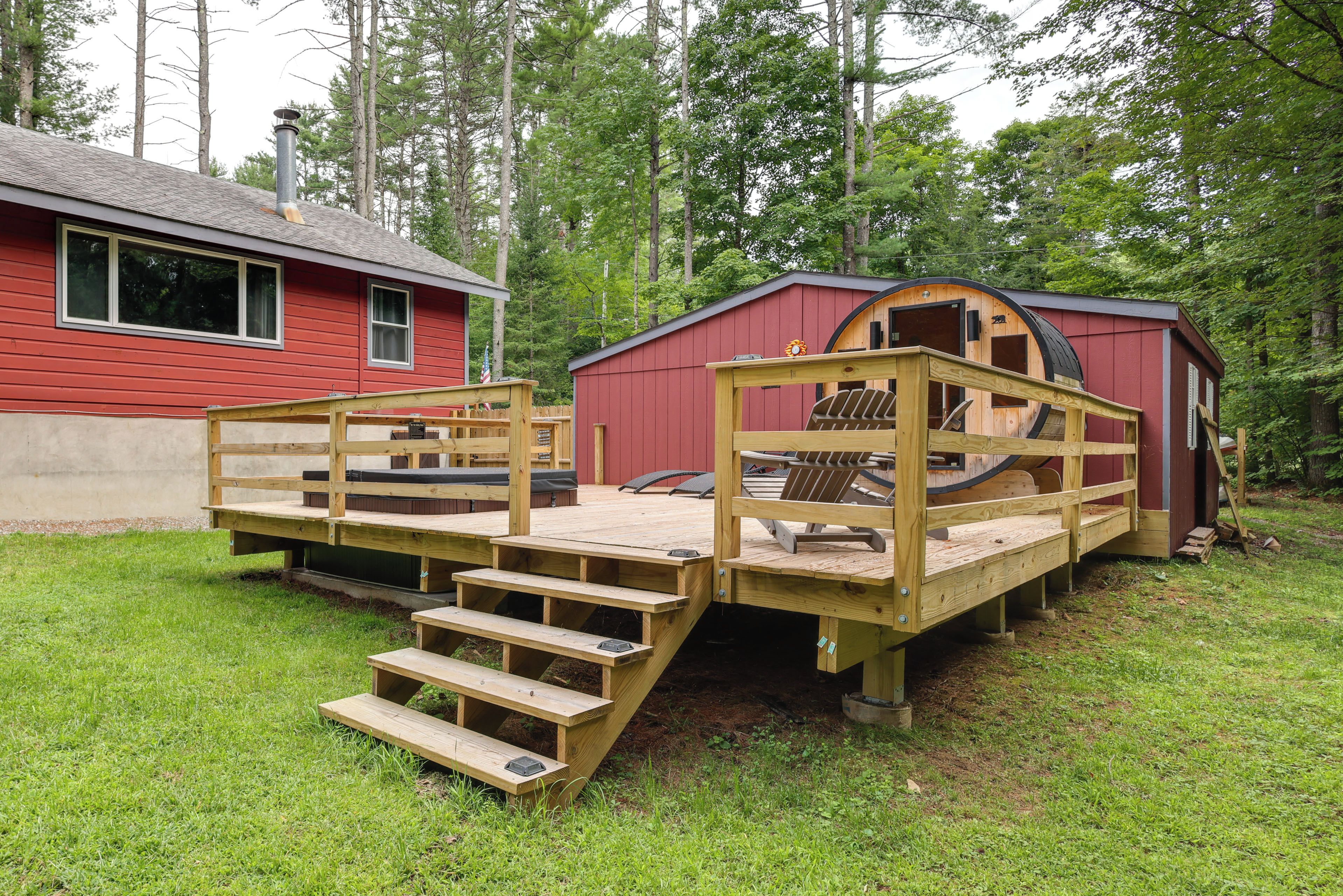 A wooden deck with a ramp leading to a covered seating area with chairs and a table.