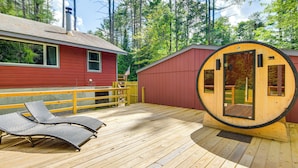 A wooden deck with two lounge chairs, a sauna, and a red building with a chimney. - Forested Retreat w/ Sauna: 5 Mi to Schroon Lake (Schroon Lake)