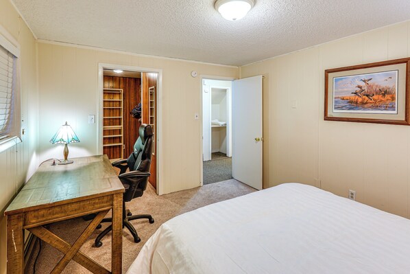 A bedroom with a bed, a desk with a lamp, a chair, and a closet. - Riverside Retreat: Cozy Fairbanks Home w/ View (Fairbanks)
