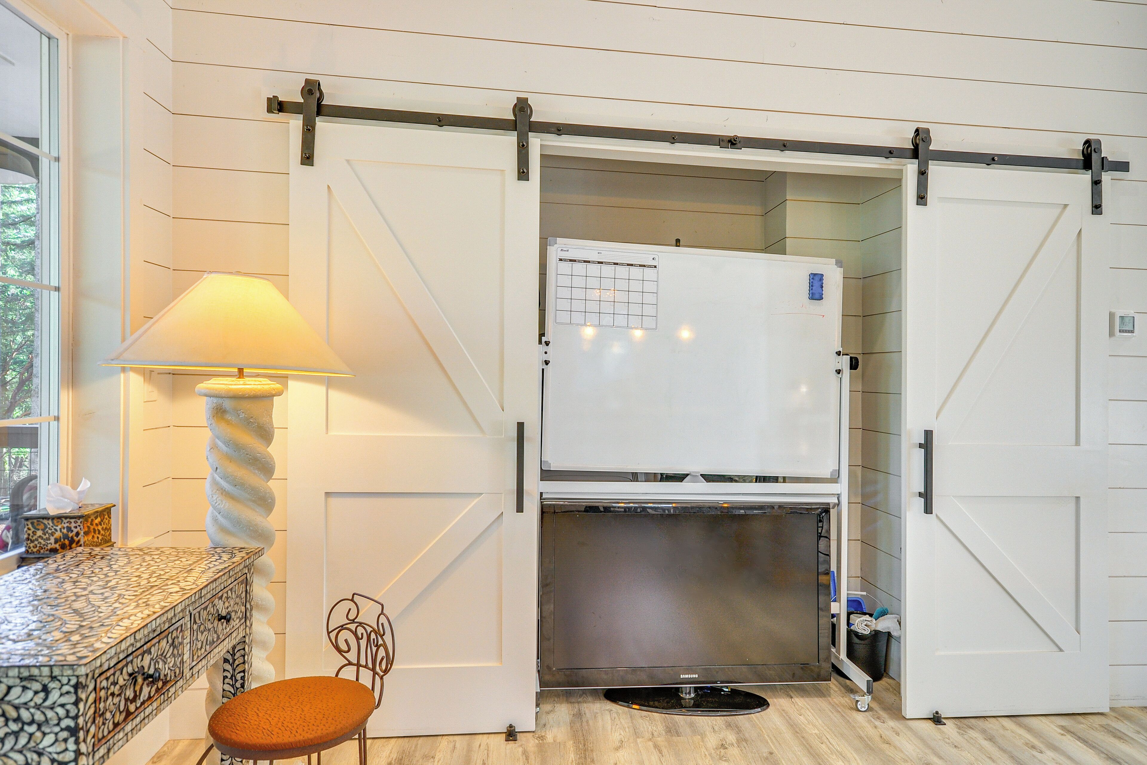A kitchen with a white refrigerator, a built-in oven, and a sliding door.