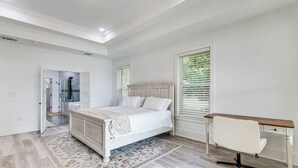 A bedroom with a bed, desk, and a walk-in closet. - Waterfront Retreat w/ Outdoor Oasis in Pensacola (Pensacola)