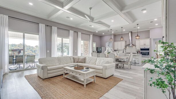 A spacious living room with a sectional sofa, a coffee table, and a large window offering a view of the outdoors. - Waterfront Retreat w/ Outdoor Oasis in Pensacola (Pensacola)