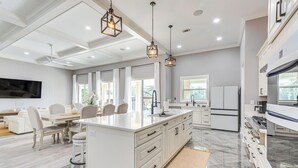 A spacious kitchen with a large island, white cabinetry, and a modern design. - Waterfront Retreat w/ Outdoor Oasis in Pensacola (Pensacola)