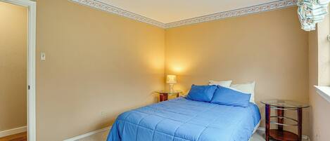 A bedroom with a bed, a nightstand, and a lamp.