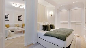 Une chambre moderne avec un grand lit, un canapé blanc et une table basse.