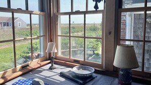 A room with large windows, a lamp, a bowl, and a mat. - Unique Coastal Retreat in Exclusive Condo Complex (2392) (Truro)