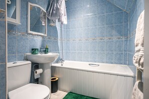 Un baño con una bañera blanca, un lavabo y un inodoro.
