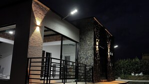 A modern building with a stone facade, large windows, and a metal railing.