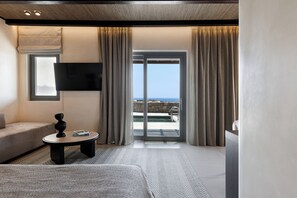 A modern hotel room with a sofa, a round table, a flat-screen TV, and a sliding glass door leading to a pool. -  Maximus Mykonos (Mykonos)