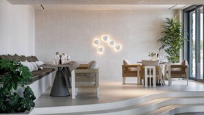 Un interior moderno con comedor, asientos y una escalera.