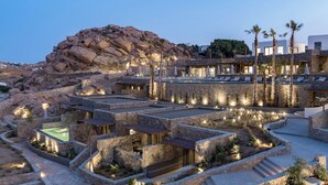 Un resort con arquitectura de piedra, mobiliario exterior y zona de piscina.