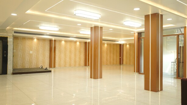 Un vestíbulo espacioso con piso pulido, paneles de madera y luminarias modernas.