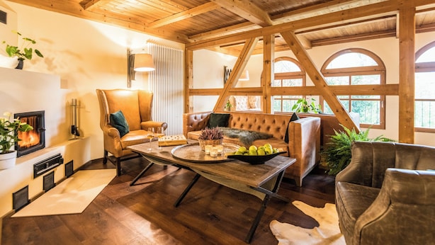 A cozy living room with a fireplace, leather furniture, and large windows. - Landhaus & Lodges by Bollants (Bad Sobernheim)