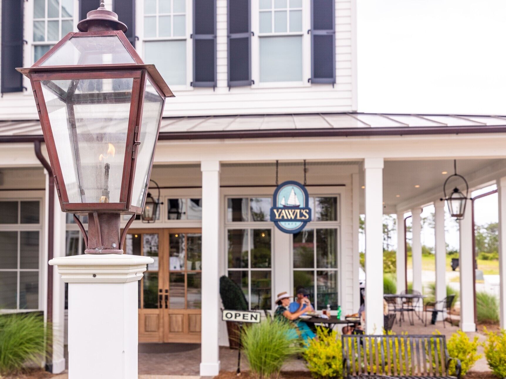 Un restaurant avec une enseigne portant l’inscription « YAWL’S » et un panneau « OUVERT » à l’extérieur.