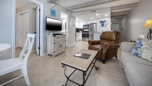 A living room with a TV, a sofa, a chair, and a coffee table. - Island Winds East 610 2 Bedroom Condo (Gulf Shores)