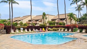 A swimming pool with lounge chairs and palm trees. - Maui Kamaole, #a-106 1 Bedroom Condo (Kihei)